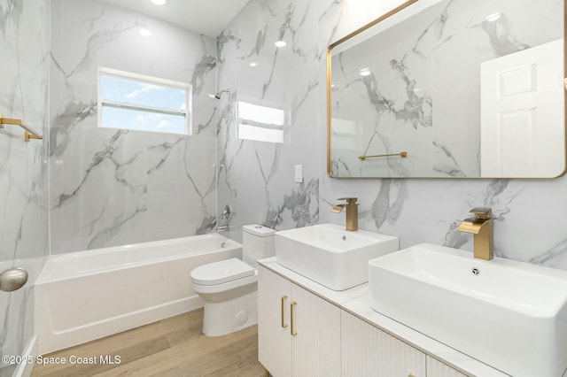 full bathroom featuring tiled shower / bath, hardwood / wood-style floors, vanity, and toilet