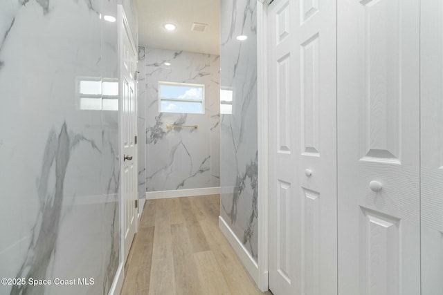 bathroom featuring hardwood / wood-style flooring and tiled shower