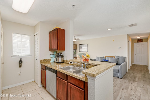 kitchen featuring sink, ceiling fan, a textured ceiling, stainless steel dishwasher, and kitchen peninsula