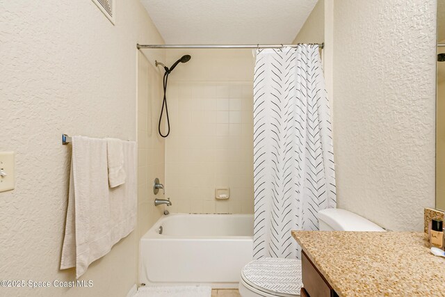 full bathroom featuring vanity, shower / tub combo with curtain, a textured ceiling, and toilet