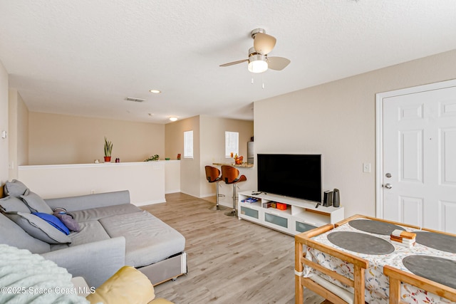 living room with light hardwood / wood-style floors and ceiling fan