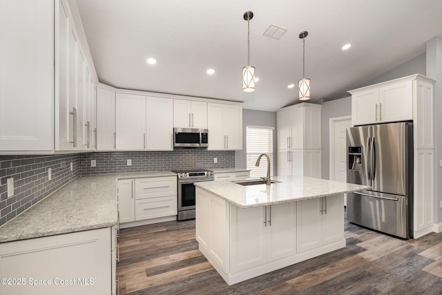 kitchen featuring appliances with stainless steel finishes, pendant lighting, white cabinets, a kitchen island with sink, and light stone counters