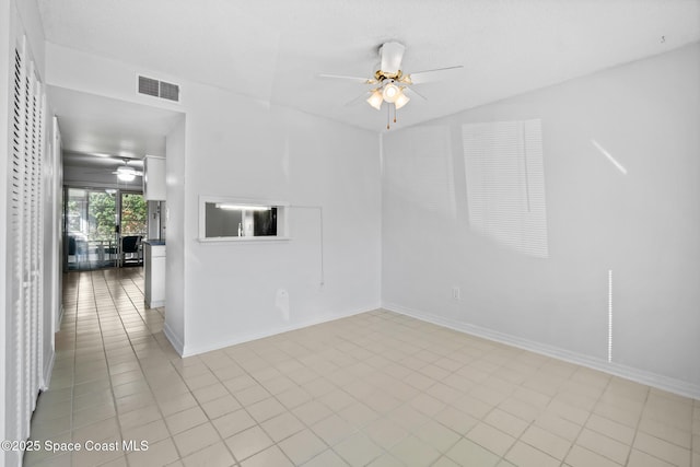 tiled empty room featuring ceiling fan