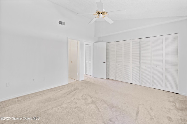 unfurnished bedroom with light carpet, high vaulted ceiling, and ceiling fan