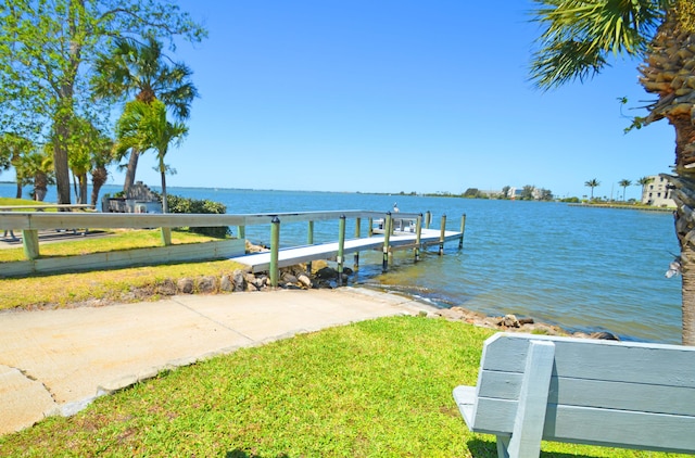 dock area with a water view and a yard