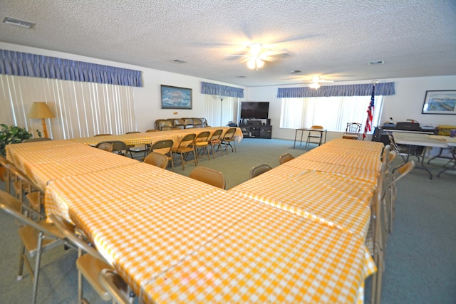 carpeted dining area with ceiling fan and a textured ceiling