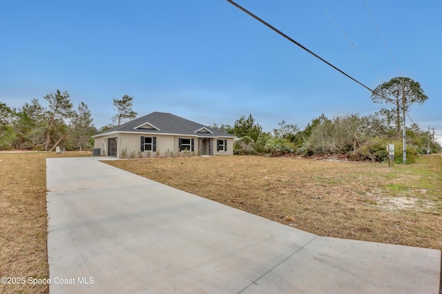 view of front facade featuring a garage, concrete driveway, and a front yard