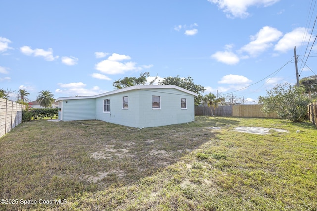 rear view of property featuring a lawn