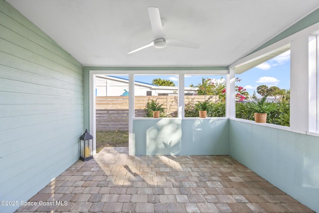 unfurnished sunroom with vaulted ceiling and ceiling fan