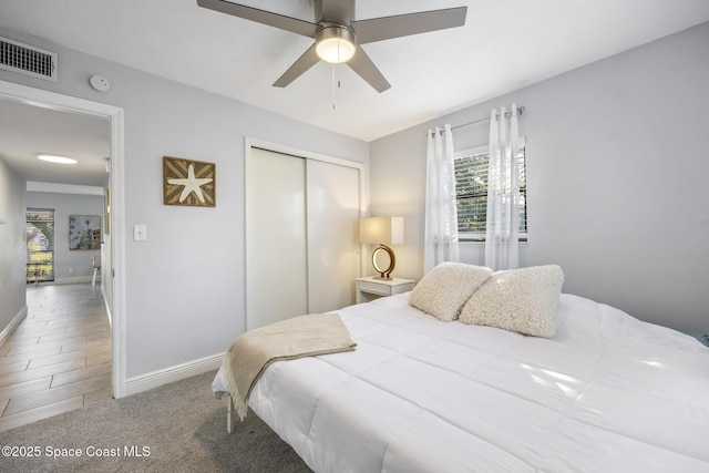 bedroom with ceiling fan, carpet flooring, and a closet