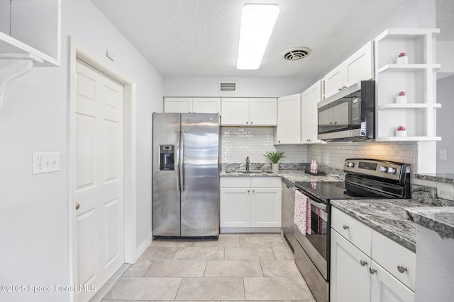 kitchen with appliances with stainless steel finishes, sink, backsplash, white cabinets, and light stone counters