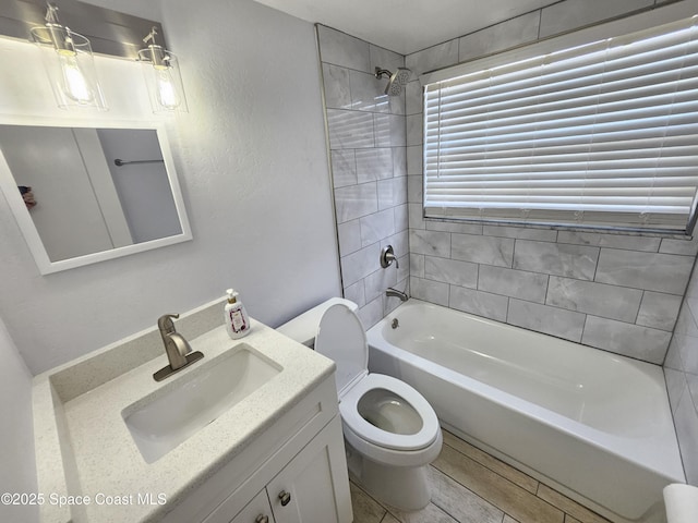 full bathroom featuring hardwood / wood-style floors, vanity, toilet, and tiled shower / bath