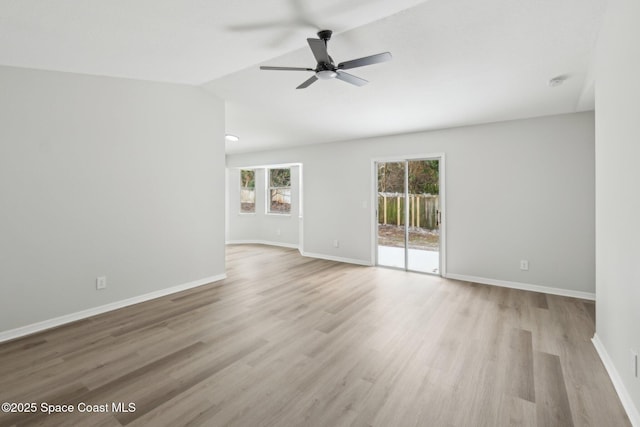 spare room with vaulted ceiling, a wealth of natural light, ceiling fan, and light hardwood / wood-style flooring