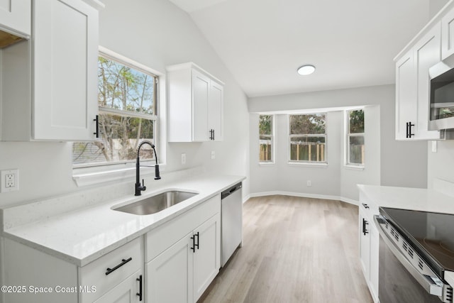 kitchen with white cabinetry, sink, and lofted ceiling