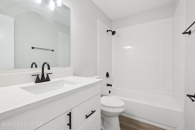 full bathroom with vanity, hardwood / wood-style floors, toilet, and tiled shower / bath