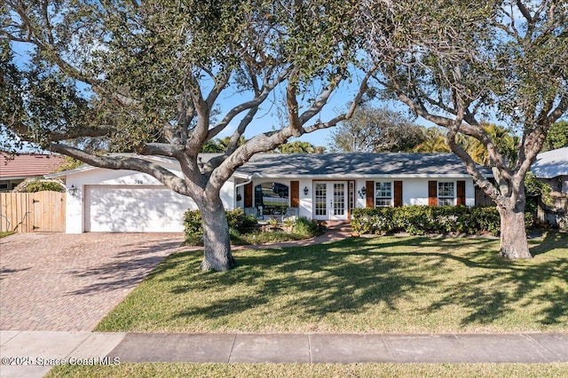 ranch-style house with a garage, a front yard, and french doors