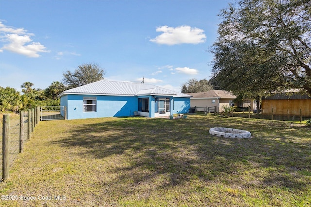 rear view of house featuring a yard and an outdoor fire pit