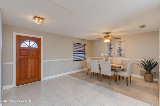 carpeted dining area with ceiling fan