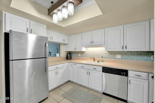 kitchen featuring sink, white cabinets, backsplash, light tile patterned floors, and stainless steel appliances