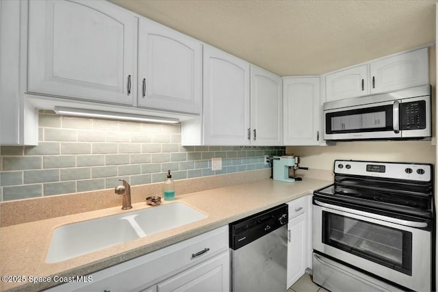 kitchen featuring tasteful backsplash, appliances with stainless steel finishes, sink, and white cabinets