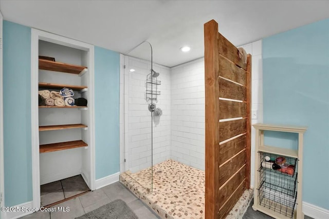 bathroom featuring tiled shower and tile patterned floors