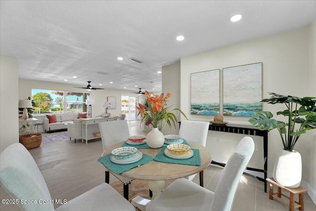 dining area with light wood-type flooring and a textured ceiling