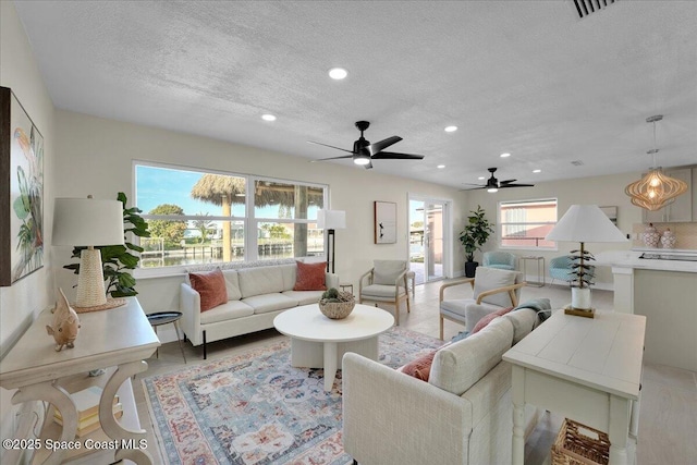 tiled living room with plenty of natural light and a textured ceiling