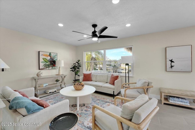 living room featuring ceiling fan and a textured ceiling