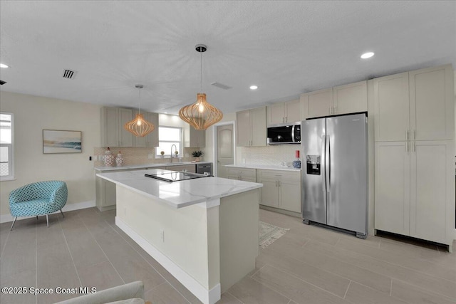 kitchen featuring tasteful backsplash, appliances with stainless steel finishes, a center island, and decorative light fixtures