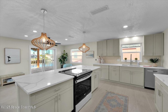 kitchen featuring sink, tasteful backsplash, decorative light fixtures, a textured ceiling, and stainless steel appliances