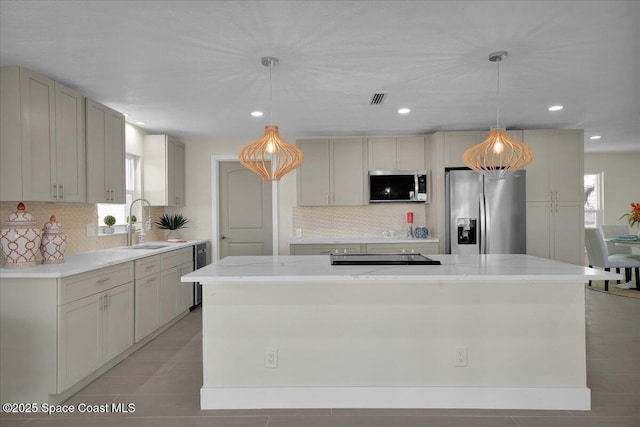 kitchen with hanging light fixtures, decorative backsplash, stainless steel appliances, and a center island