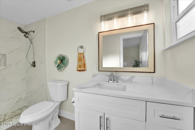 bathroom with vanity, a tile shower, and toilet