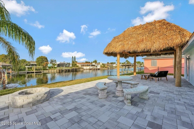 view of patio with an outdoor fire pit and a water view