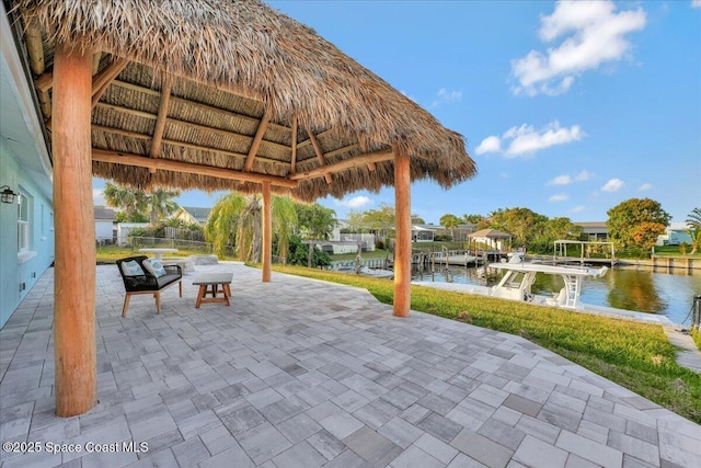 view of patio with a gazebo, a dock, and a water view