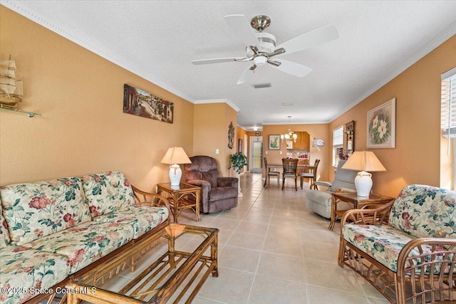 tiled living room featuring crown molding, ceiling fan with notable chandelier, and a textured ceiling