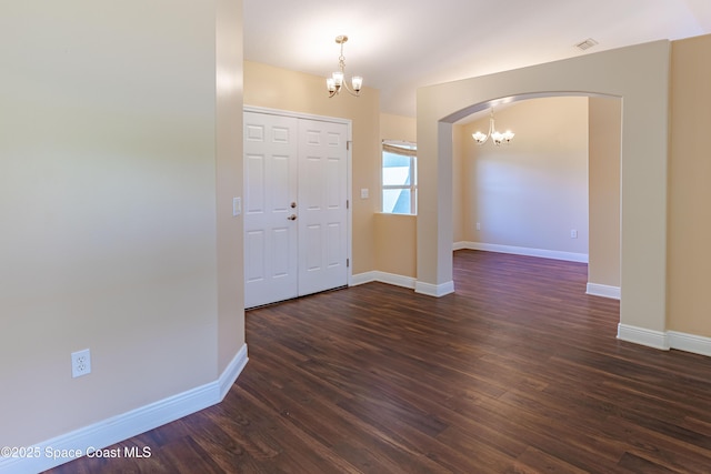 foyer entrance featuring an inviting chandelier and dark hardwood / wood-style flooring