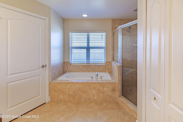 bathroom featuring tile patterned flooring and separate shower and tub