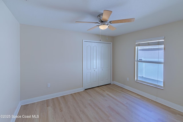 unfurnished bedroom featuring a closet, ceiling fan, and light wood-type flooring