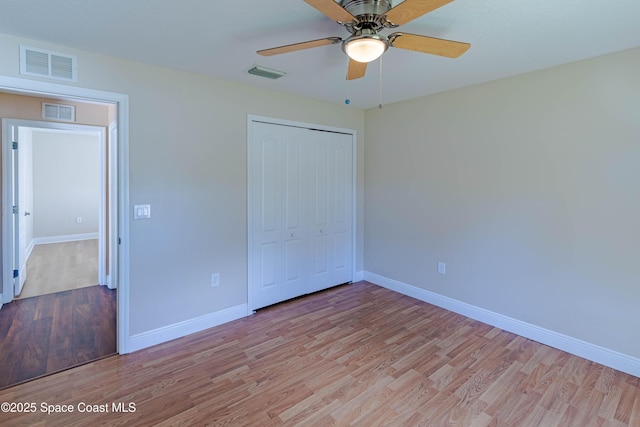 unfurnished bedroom featuring light hardwood / wood-style floors, ceiling fan, and a closet