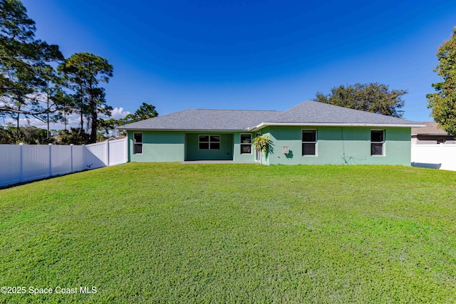 rear view of property with a lawn