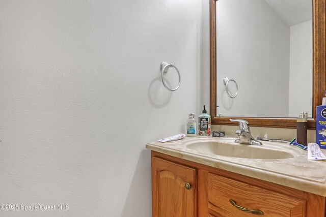 bathroom featuring lofted ceiling and vanity