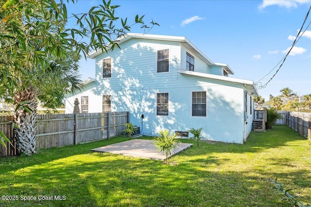 back of property with a patio area and a lawn