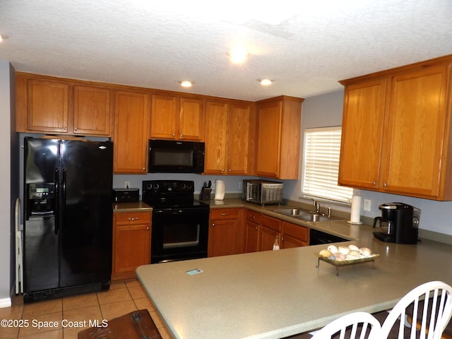 kitchen with black appliances, sink, light tile patterned floors, kitchen peninsula, and a textured ceiling