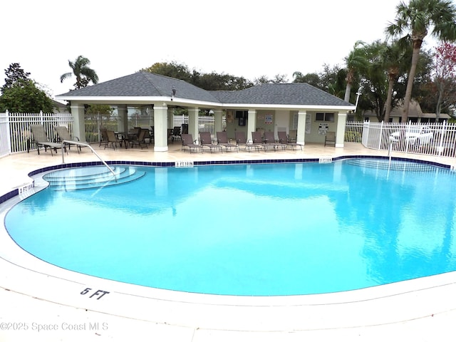 pool with a patio area and fence