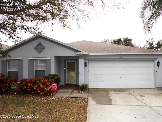 ranch-style home featuring a garage, concrete driveway, roof with shingles, and stucco siding