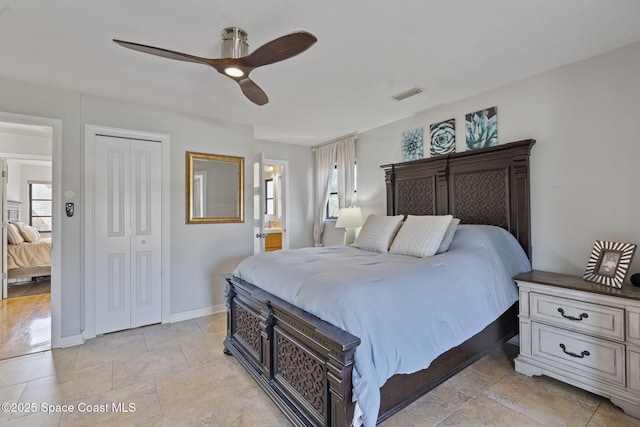 bedroom with multiple windows, ensuite bathroom, ceiling fan, and a closet