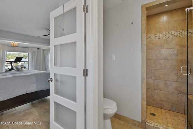 bathroom featuring a shower with shower door and toilet