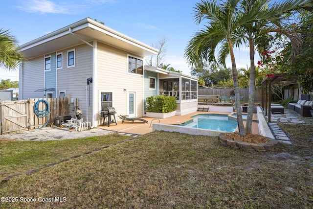 back of house with a fenced in pool, a lawn, a sunroom, and a patio