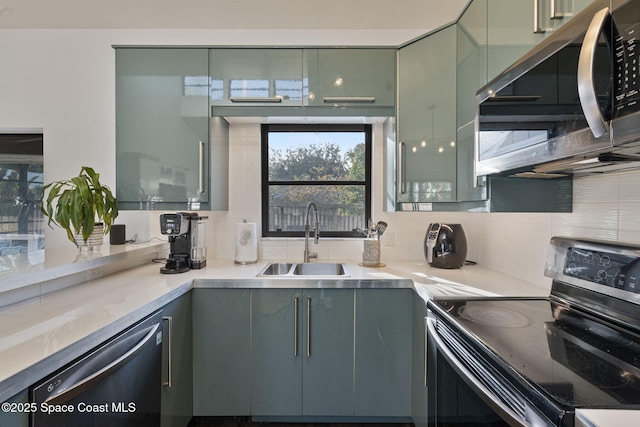 kitchen with stainless steel appliances, sink, light stone counters, and decorative backsplash