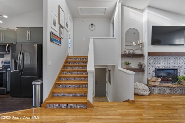 stairway with hardwood / wood-style flooring and a fireplace